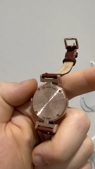 Rückseite einer Armbanduhr in Roségold mit gebogen gravierter persönlicher Widmung