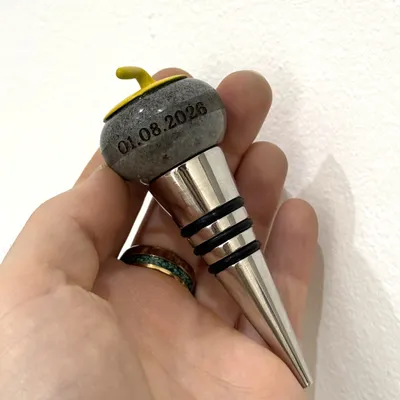 Flaschenverschluss mit Curlingstein aus Granit, in den ein Datum graviert ist