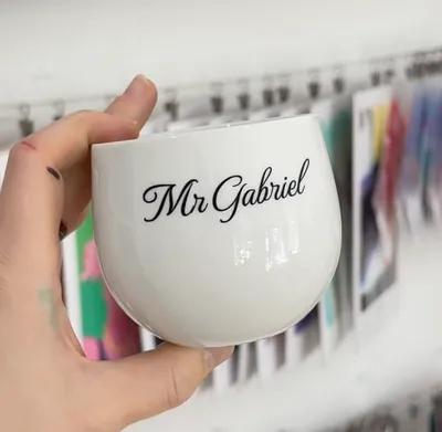 Weiße Keramiktasse mit graviertem Namenszug, die Gravur ist schwarz ausgefüllt