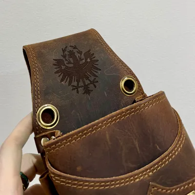 Braune Ledertasche mit großflächig graviertem Adler auf der Verschlusslasche