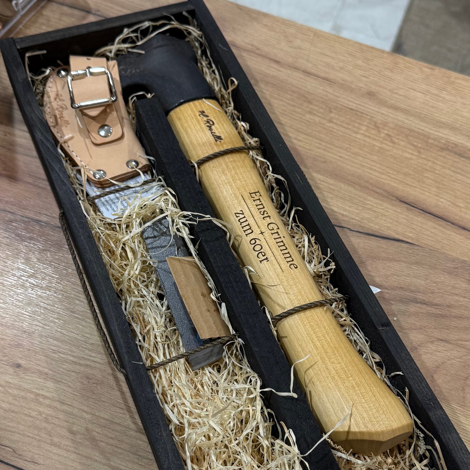 Messer und Wetzstahl in einer Holzkiste, der helle Holzgriff trägt Name und Anlass