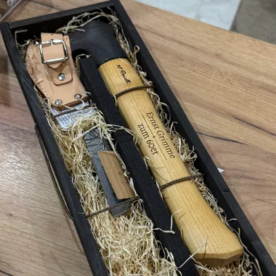 Messer und Wetzstahl in einer Holzkiste, der helle Holzgriff trägt Name und Anlass