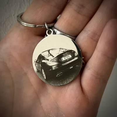 Runder Schlüsselanhänger aus Metall mit der Fotogravur eines Autos von hinten