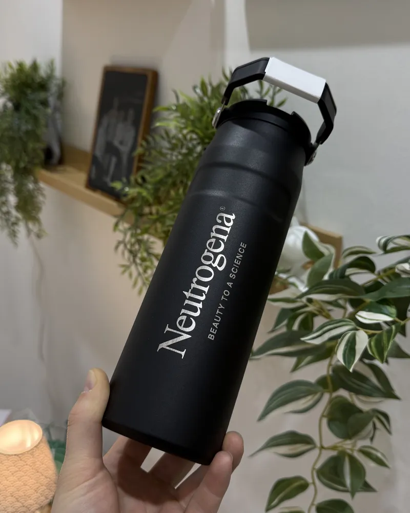 Schwarze Trinkflasche aus Metall mit hell graviertem Firmenlogo und Claim