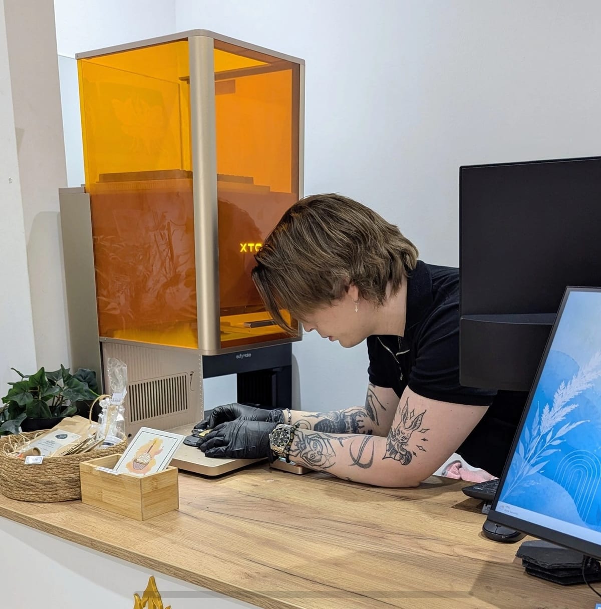 Arbeitsplatz mit Lasergerät und Bildschirm, eine Person richtet ein Werkstück ein